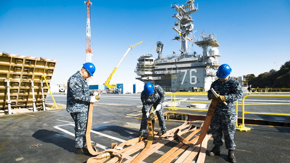 Albert Mendez and Mates Perform Maintenance on a Hose of an Aqueous Film Forming Foam (AFFF) Station