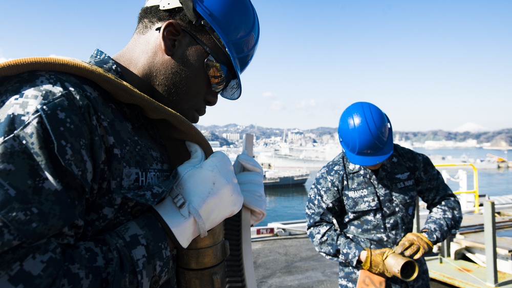Albert Mendez and Mates Perform Maintenance on a Hose of an Aqueous Film Forming Foam (AFFF) Station