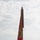 A military change of command ceremony is taking place on an aircraft flight line, with two Marine Corps officers exchanging a unit guidon (flag). The red flag bears the Eagle, Globe, and Anchor emblem of the United States Marine Corps, with multiple battle streamers attached at the top. Military jet aircraft, consistent with F-35B fighters, are visible in the background.