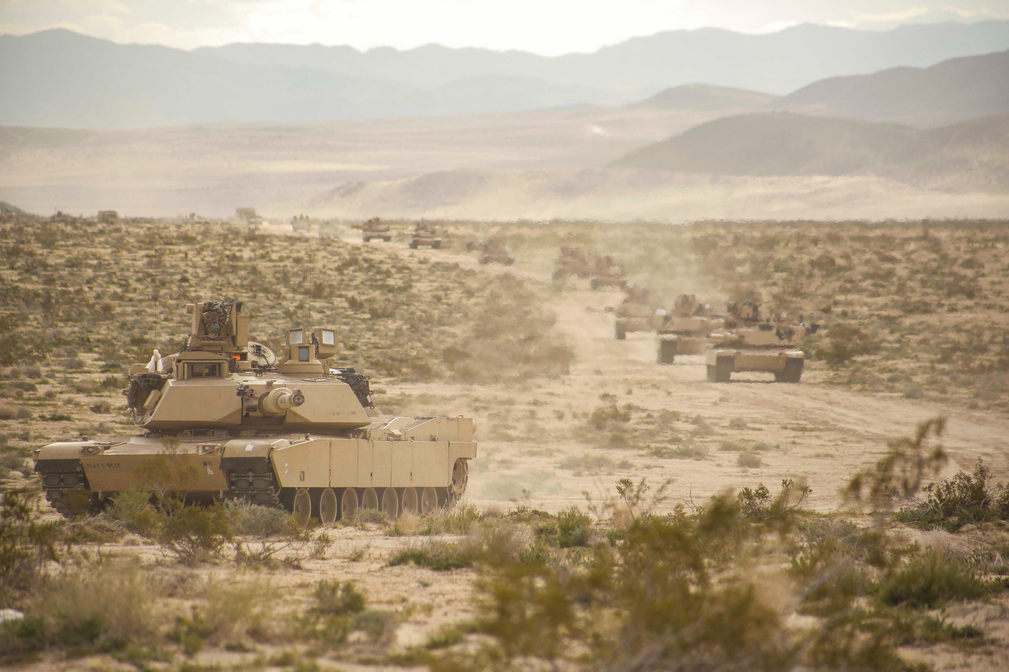 Military tanks in a desert training convoy