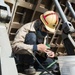 Tsugifugi Tsubasa, a Sumitomo Heavy Industries welder and fitter, from Yokosuka, Japan, wraps the end of a pneumatic hose with tape
