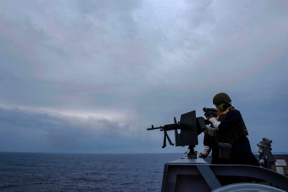 Green Bay Sailors fire an M240B machine gun off the ship