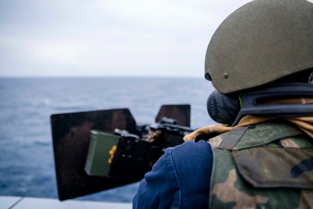 Green Bay Sailors fire an M240B machine gun off the ship