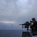 Green Bay Sailors fire an M240B machine gun off the ship