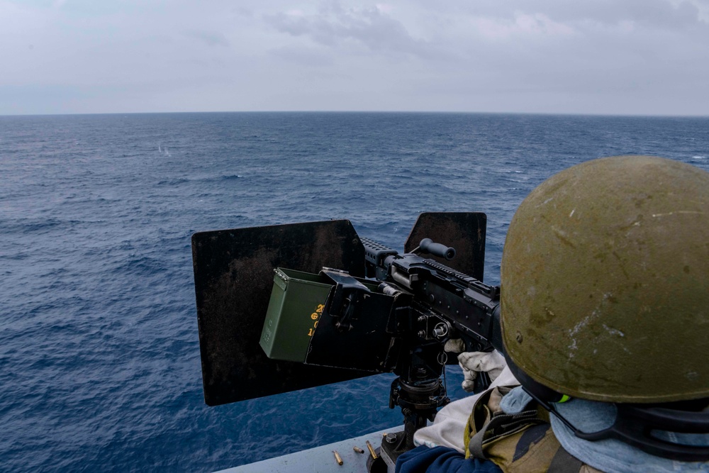 Green Bay Sailors fire an M240B machine gun off the ship