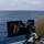 Green Bay Sailors fire an M240B machine gun off the ship