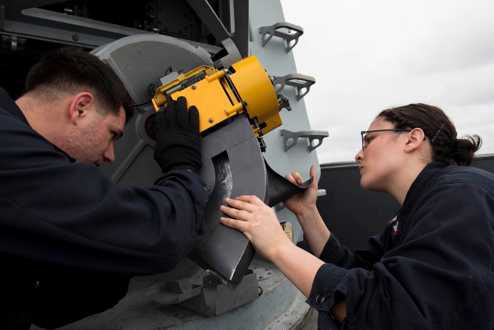 Fire Controlmen install a loader unit onto a Close-In Weapons System (CIWS)