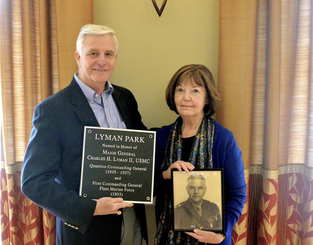 Retired Col. Chalres H. Lyman IV and Wife Holding Memorial Plaque and Photo of Grandfather