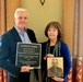 Retired Col. Chalres H. Lyman IV and Wife Holding Memorial Plaque and Photo of Grandfather