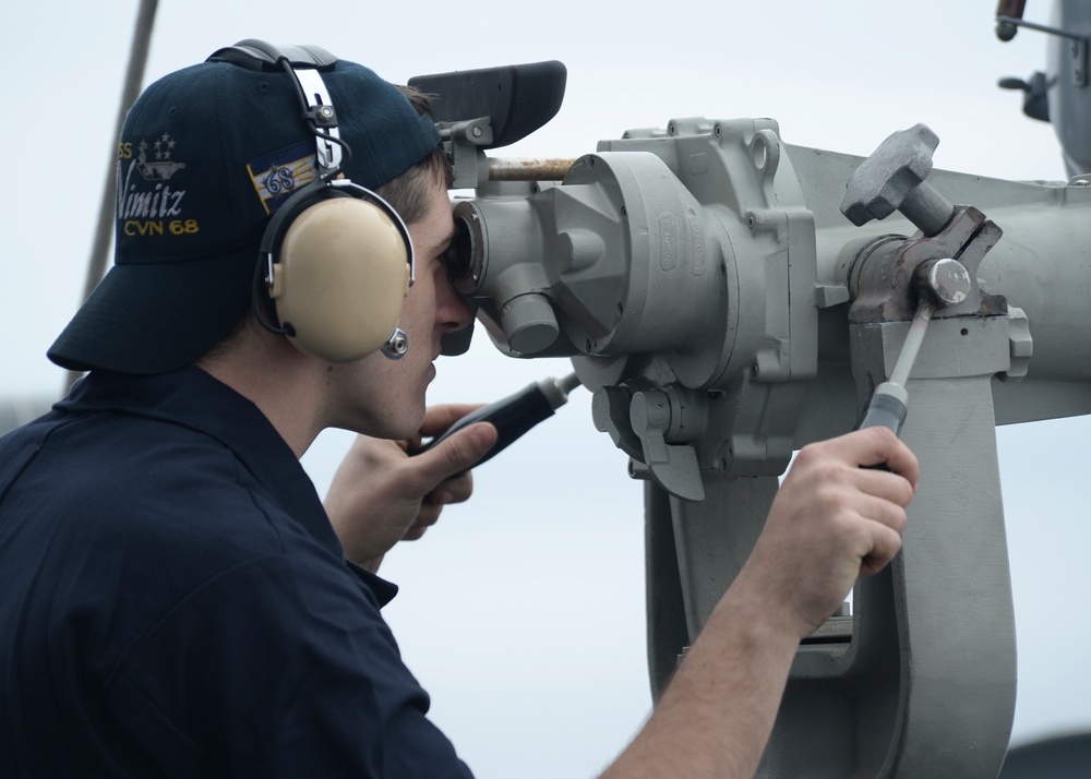 Sailors looks through scope