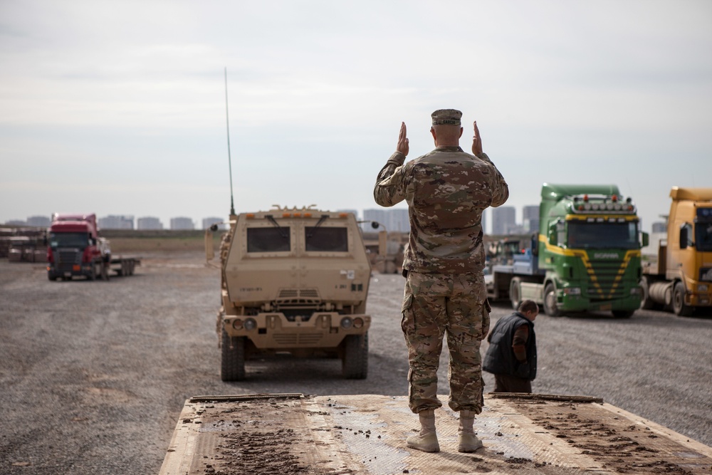 Soldiers load vehicles, HIMARS for transport