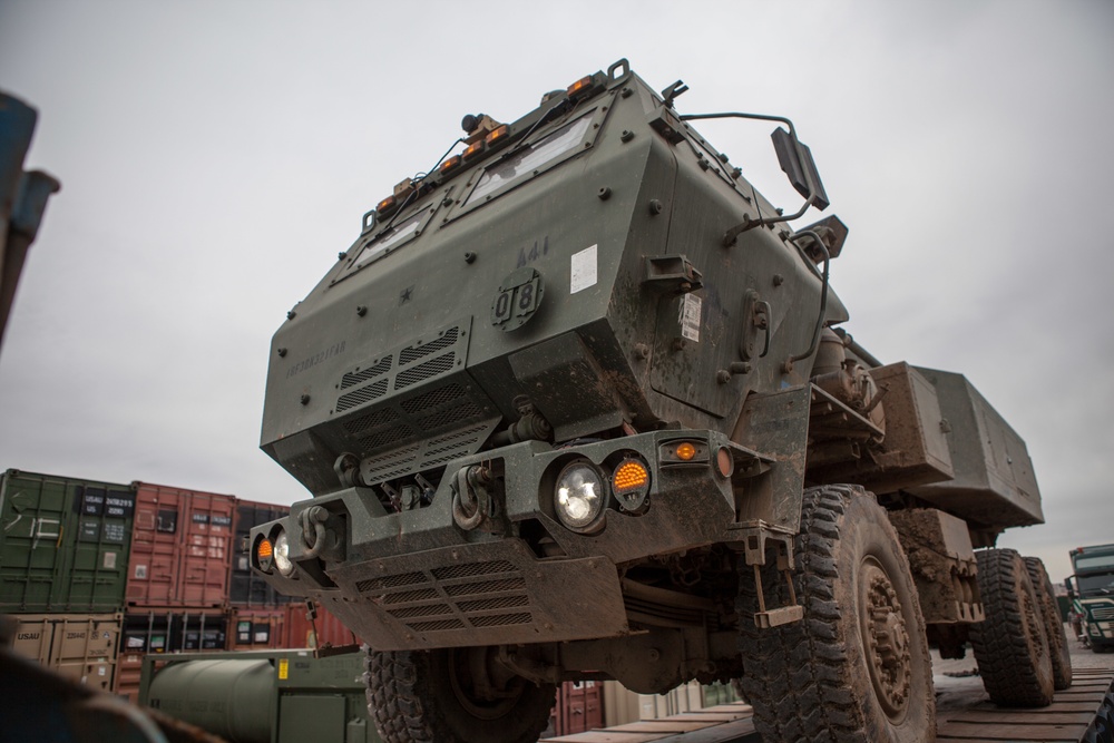 Soldiers load vehicles, HIMARS for transport