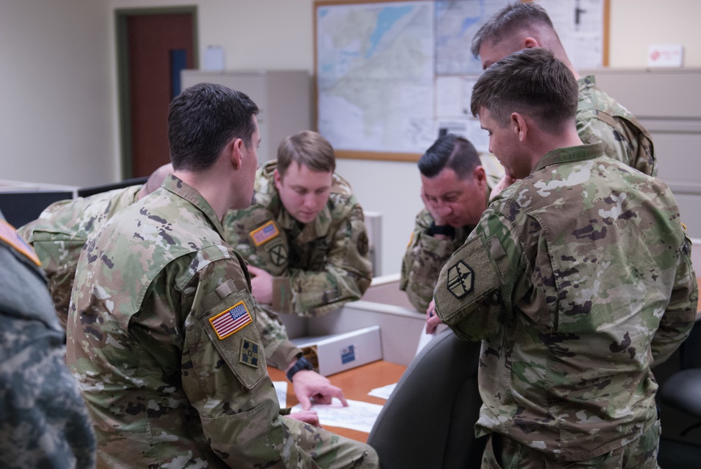 Key leadership from the 301st Maneuver Enhancement Brigade reviews a route before a convoy takes place