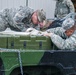 Soldiers from Headquarters and Headquarters Company, 301st Maneuver Enhancement Brigade, prepare a truck to carry cargo before a convoy departs