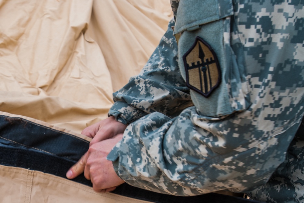 A soldier from Headquarters and Headquarters company, 301st Maneuver Enhancement Brigade, assembles a deployable rapid assembly shelter