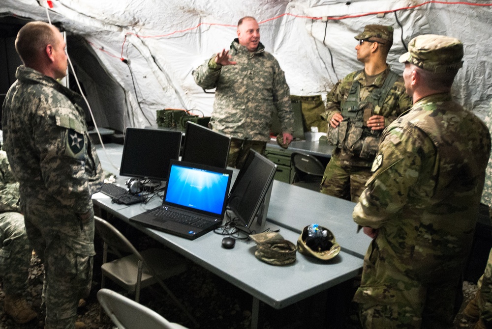 Leaders from the 301st Maneuver Enhancement Brigade discuss future movement plans inside of the 301st Maneuver Enhancement Brigade tactical operations center