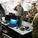 Leaders from the 301st Maneuver Enhancement Brigade discuss future movement plans inside of the 301st Maneuver Enhancement Brigade tactical operations center