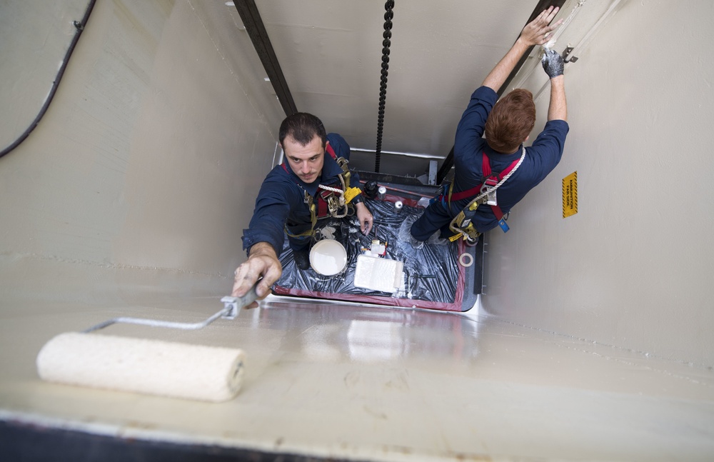 Gunner’s Mate 3rd Class Zachary Larkin and  and Fire Controlman 3rd Class Jose Gonzalez Paint the Interior of an Ordnance Lift Aboard USS Michael Murphy