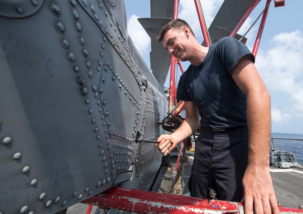 Aviation Machinist’s Mate 3rd Class Leo Stapleton Loosens a Bolt on the Tail Pylon of an MH-60R Helicopter Aboard USS Michael Murphy