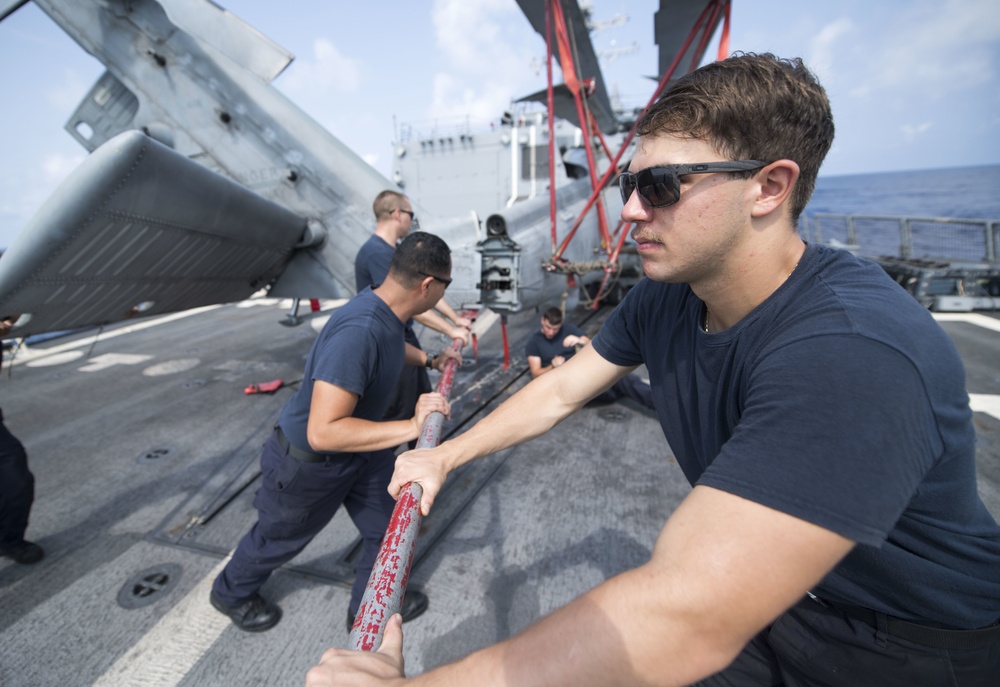 Aviation Electrician’s  Mate 3rd Class Dominick Strona Helps Fold the Tail Pylon of an MH-60R Helicopter Aboard USS Michael Murphy (DDG 112)