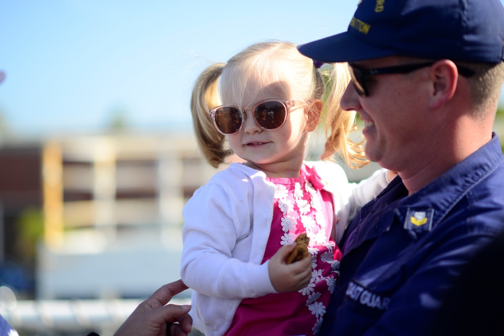 A father puts sunglasses on his daughter