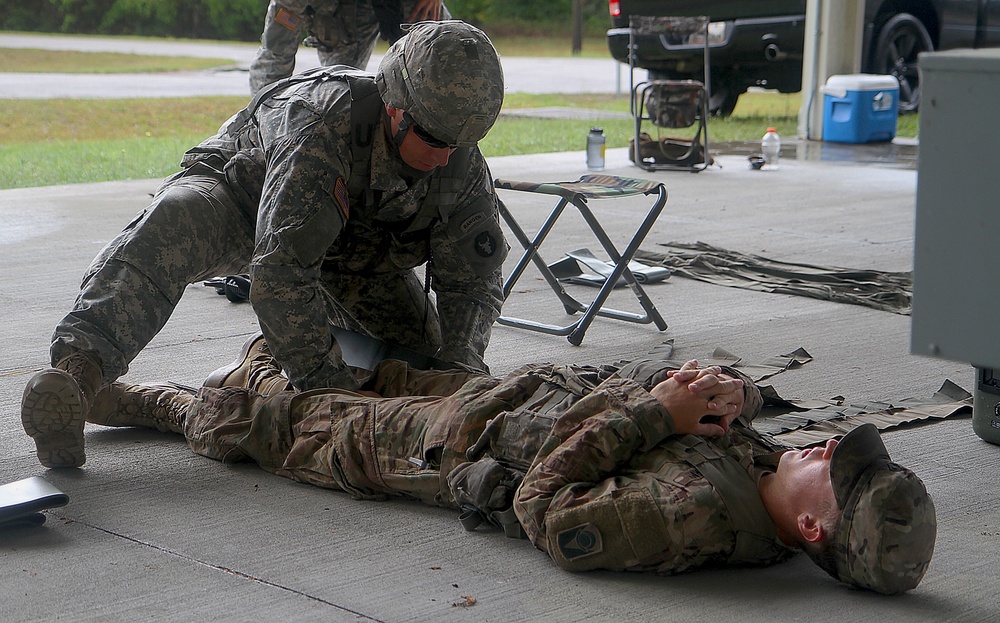 National Guard Solider treats mock burn victim during Expert Infantry Badge qualifications