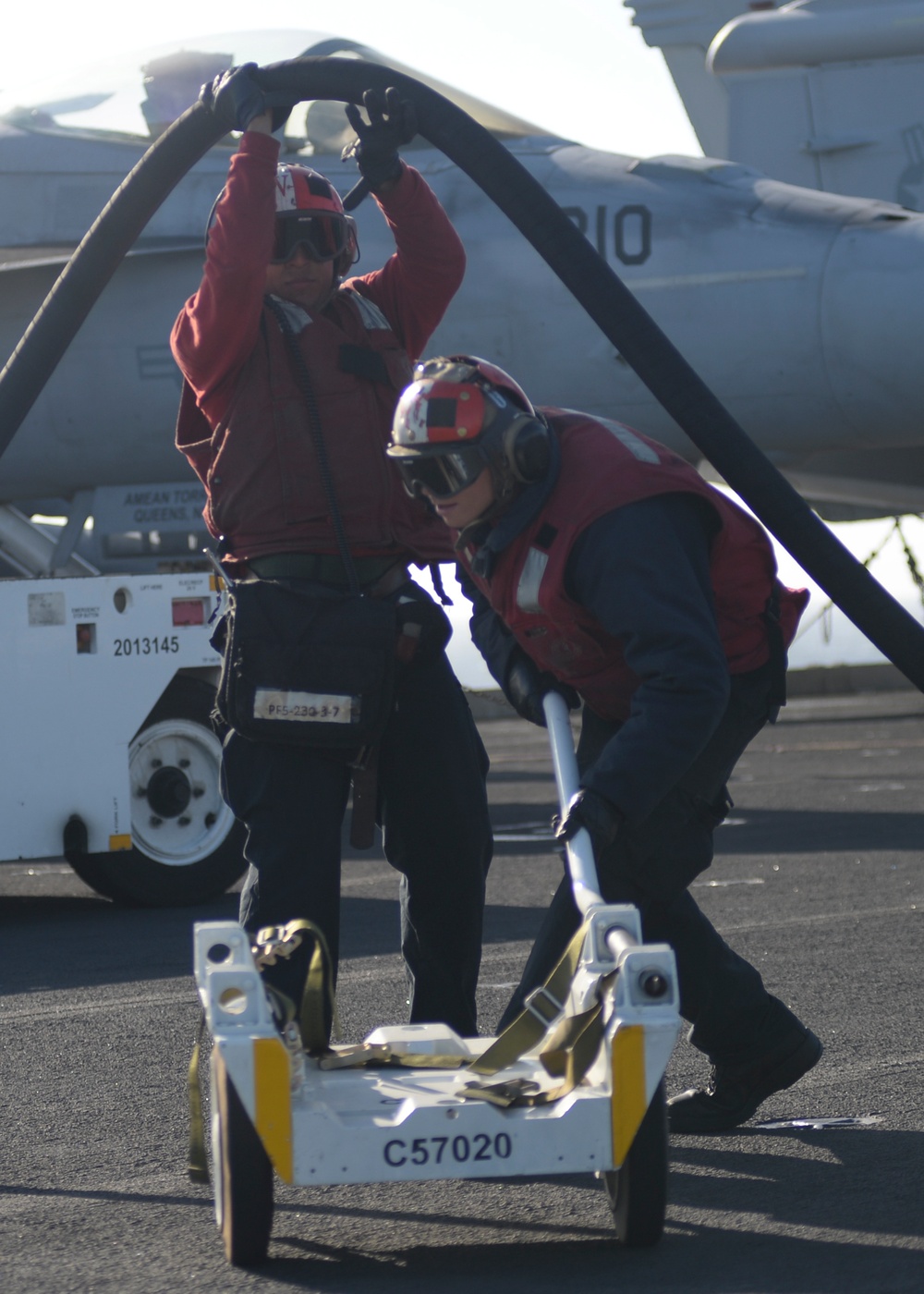 Sailor helps Sailor under fuel hose