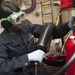 Fireman Mercy Ngatia Conducts Maintenance on a Potassium Bicarbonate Fire Extinguisher