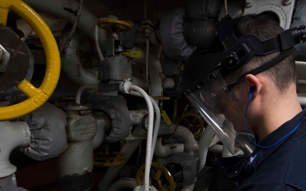 Gas Turbine System Technician (Mechanical) 3rd Class David Matthews takes a fuel sample in auxiliary space 1 aboard USS Leyte Gulf (CG 55)
