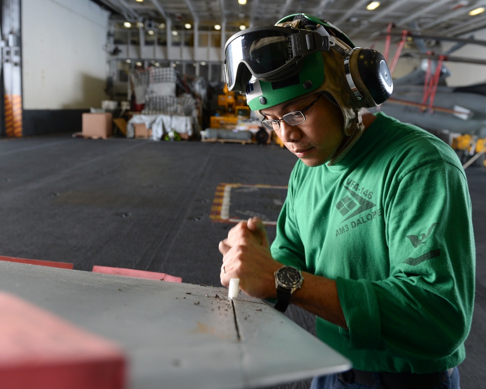 Sailors cleans airplane wing