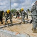 Soldiers with the 672nd Engineer Company work with soldiers with the Belize Defense Force to spread and compact gravel