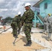 Soldiers assigned to the 301st Maneuver Enhancement Brigade work with soldiers with the Belize Defense Force to spread and compact gravel