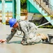 Chief Warrant Officer 2 Steven Heavrin uses a trowel to smooth a concrete slab to perfection