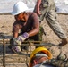 A soldier with the Belize Defense Force secures a chair to a rebar footer cage