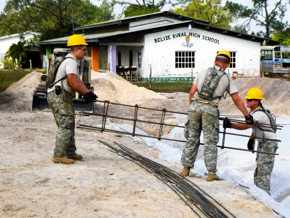 Soldiers with the 301st Maneuver Enhancement Brigade, place a rebar form cage