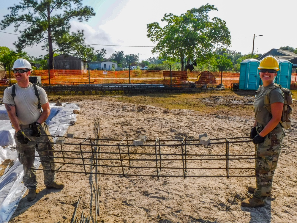 Sgt. Roman Firestone and Pvt. Jade Smith carry a rebar form cage