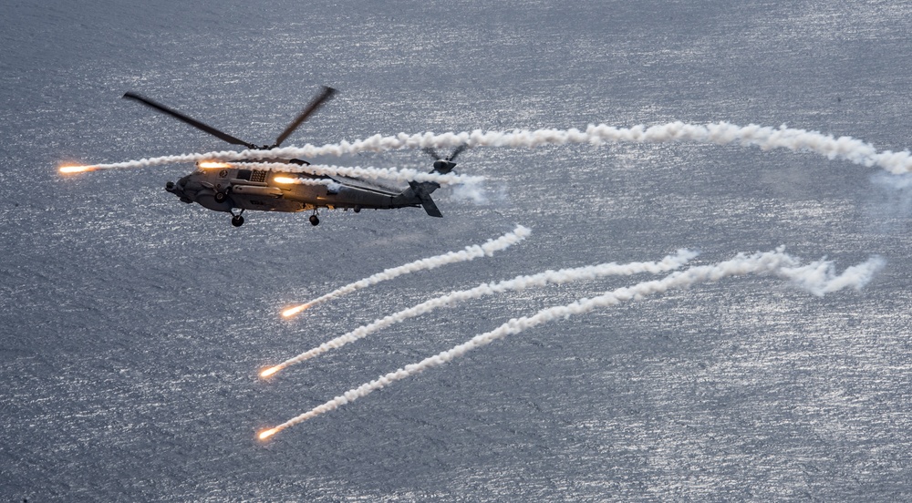 An MH-60R Sea Hawk from the Helicopter Maritime Strike Squadron (HSM) 78 “Blue Hawks” fires chaff flares during a training exercise near the aircraft carrier USS Carl Vinson (CVN 70)