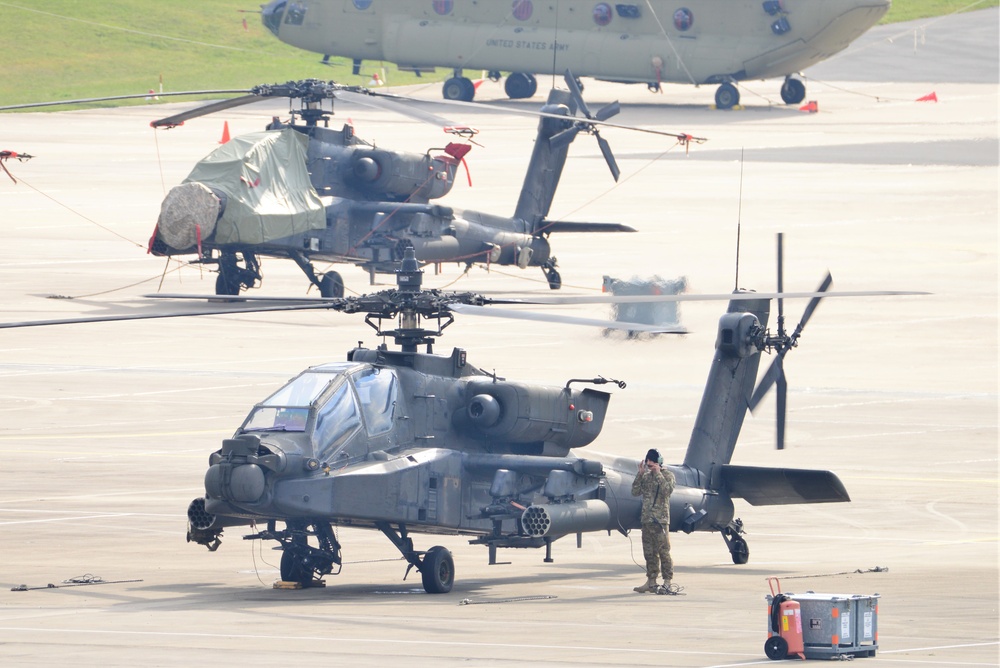 Apache Helicopters on flight line  conduct a radio maintenance check.