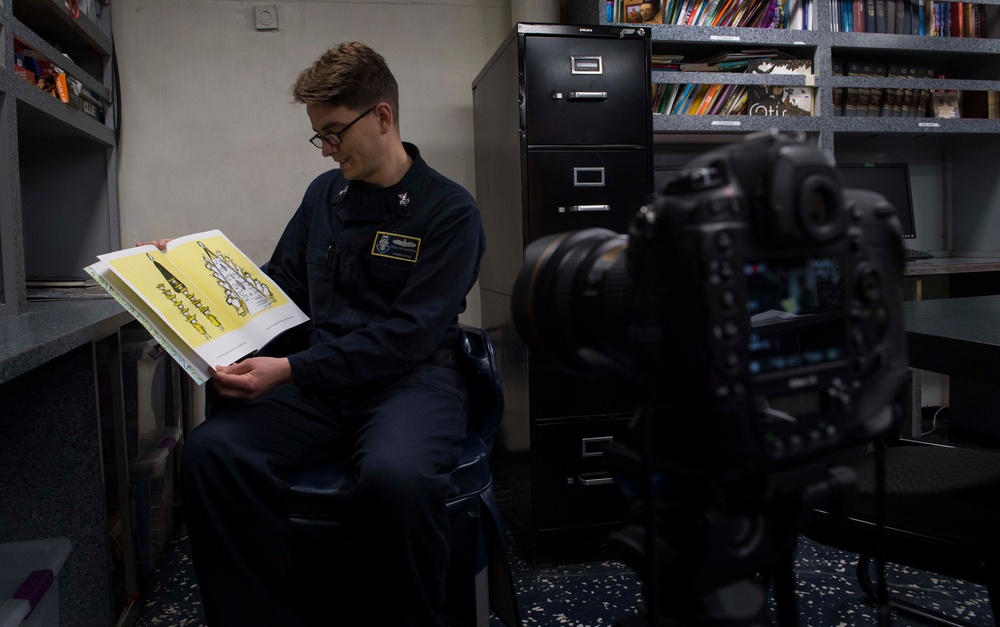 1st Class Cecil Chapman reads in the library of the Ticonderoga-class guided missile cruiser USS Leyte Gulf (CG 55) as part of the United Through Reading program