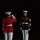Marine Barracks Washington Evening Parade April 28, 2017 Two U.S. Marine Corps personnel are photographed at night during what appears to be a formal military ceremony. One Marine in a red dress uniform is playing a bugle, while a second Marine in a blue dress uniform with sergeant major chevrons stands at attention. The scene is dramatically lit against a completely dark background.