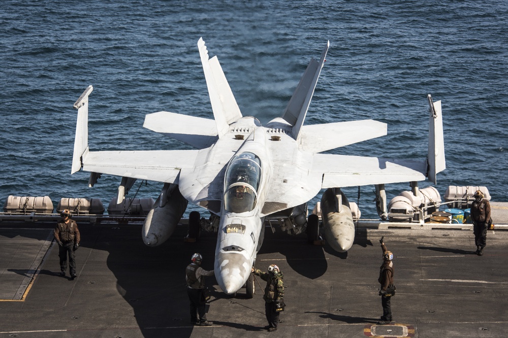 Sailors assigned to the “Bounty Hunters” of Strike Fighter Squadron (VFA) 2 perform pre-flight checks on an F/A-18F Super Hornet aboard the Nimitz-class aircraft carrier USS Carl Vinson (CVN 70)