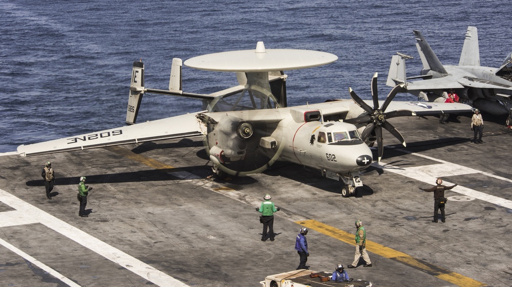Sailors perform pre-flight checks on an E-2C Hawkeye from the “Black Eagles” of Carrier Airborne Early Warning Squadron (VAW) 113 aboard the Nimitz-class aircraft carrier USS Carl Vinson (CVN 70)