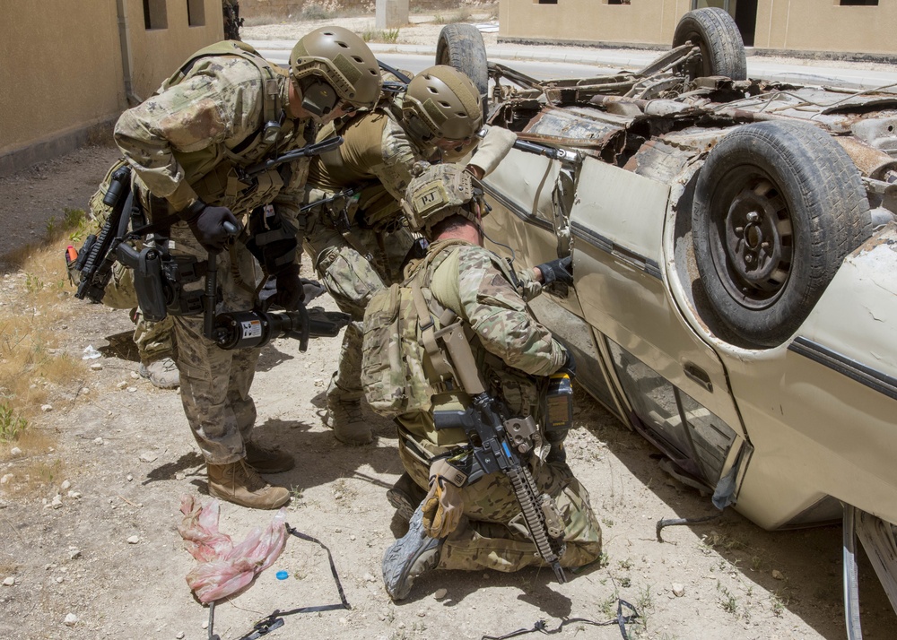 Members of the Air Force and Italian Special Operations attempt to gain access to a vehicle during a combat search and rescue exercise in support of Eager Lion 2017.