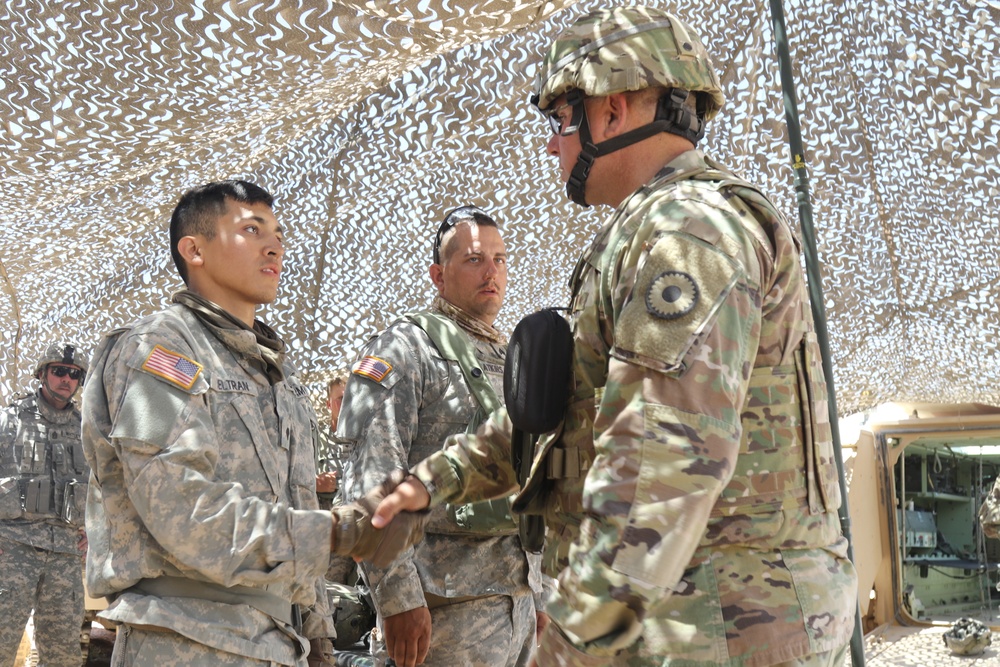 Maj. General Lee Tafanelli, the adjutant general of Kansas, presents coins to Soldiers