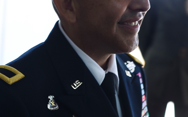 A U.S. Army officer named Castellanos is wearing a dress blue uniform with various insignia, badges, and service ribbons. The soldier displays a paratrooper badge (jump wings), a regimental distinctive insignia, and multiple service ribbons on the chest. The officer appears to be at a formal military ceremony or event.