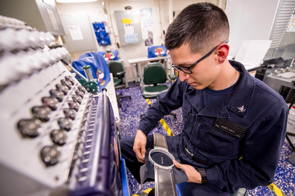 USS America Sailor reviews work of embroider machine