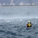 Coast Guard rescue swimmer signals helicopter during mock rescue