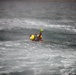 Coast Guard rescue swimmer signals helicopter during mock rescue