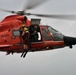 Coast Guard rescue swimmer and Jim Cantore hoisted by helicopter