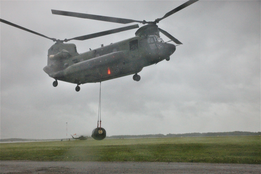 A Royal Canadian Air Force CH-147F Chinook air lifts a sling loaded helicopter expedient refueling system fuel pod